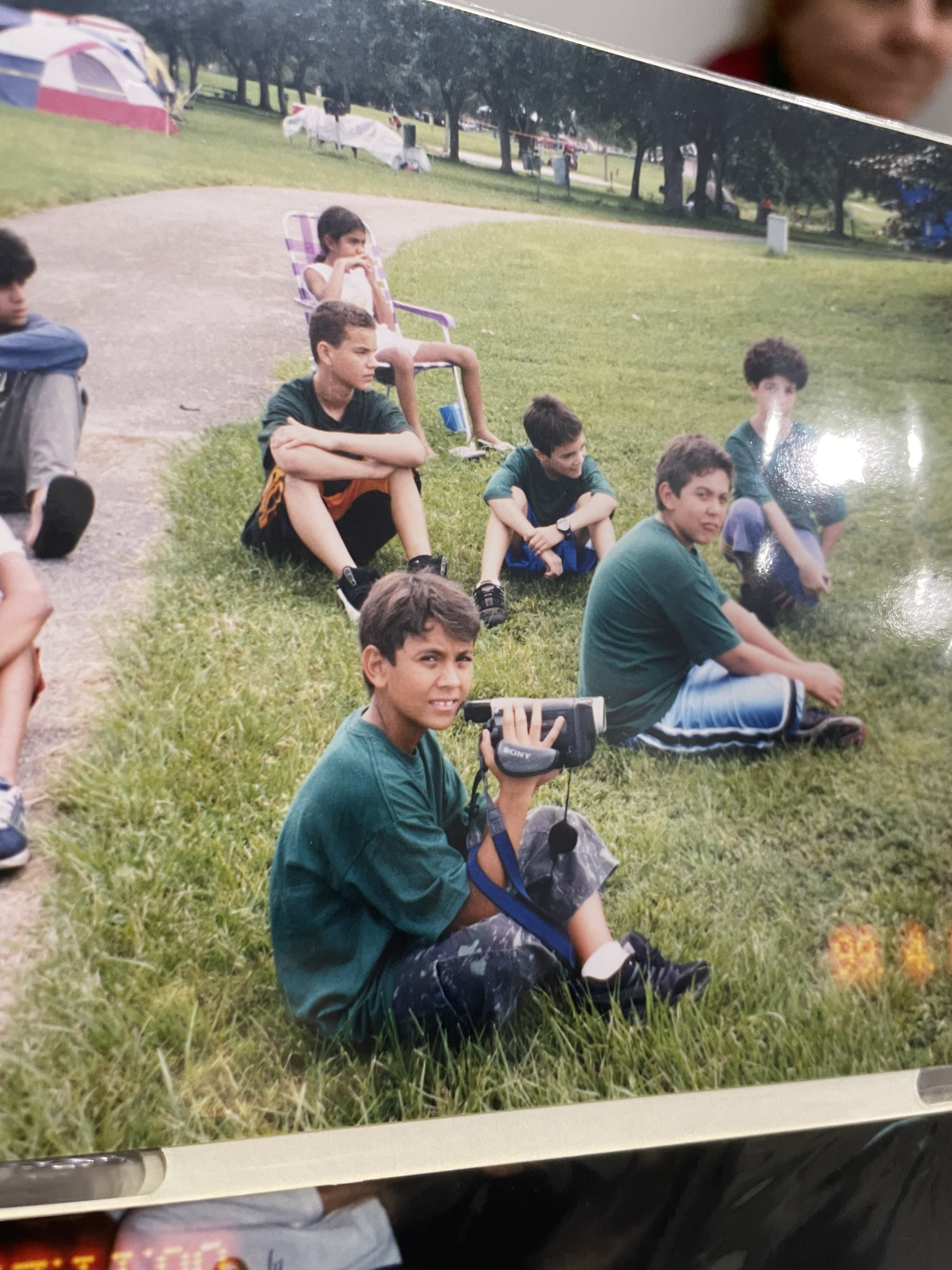Young Larry DaSilva with his first camera at a park, beginning his journey in videography